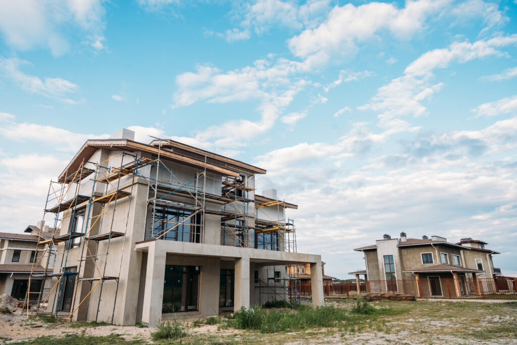 unfinished building construction with scaffolding under cloudy sky